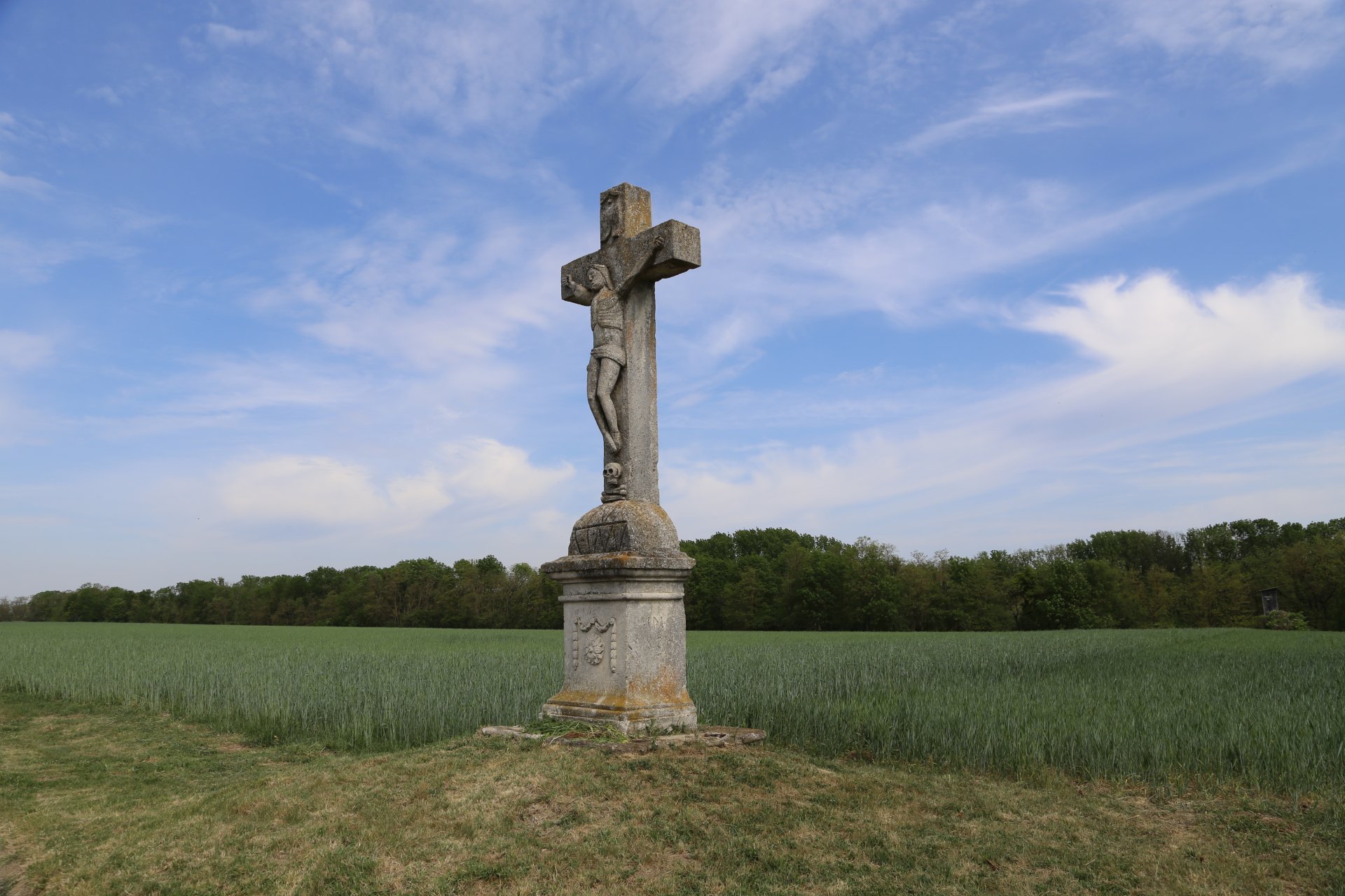 Hier hilft dir nur mehr Gott - Acker, Corpus Christi, Denkmäler, Feld, Himmel, Hochkreuz, Kreuz, Landschaft, Steinkreuz, Totenkopf, Totenschädel, Wald, Wolken - (Mitterstockstall, Niederösterreich, Österreich)