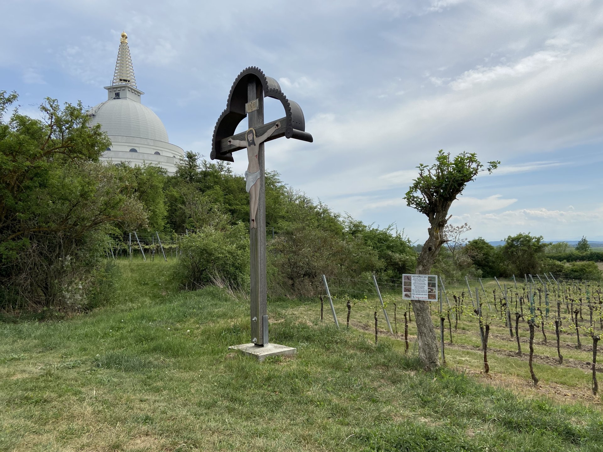 Buddha lächelt milde auf die Wanderer herunter - buddhistisch, Friedensdenkmal, Gebäude, Kreuz, Marterl, Meditationshaus, Ort des Glücks, Platz für Ruhe, Rebstöcke, Stupa, Stupa am Wagram, Tafel, Wegkreuz, Weinbau, Weinstöcke - (Wagram am Wagram, Kamp, Niederösterreich, Österreich)