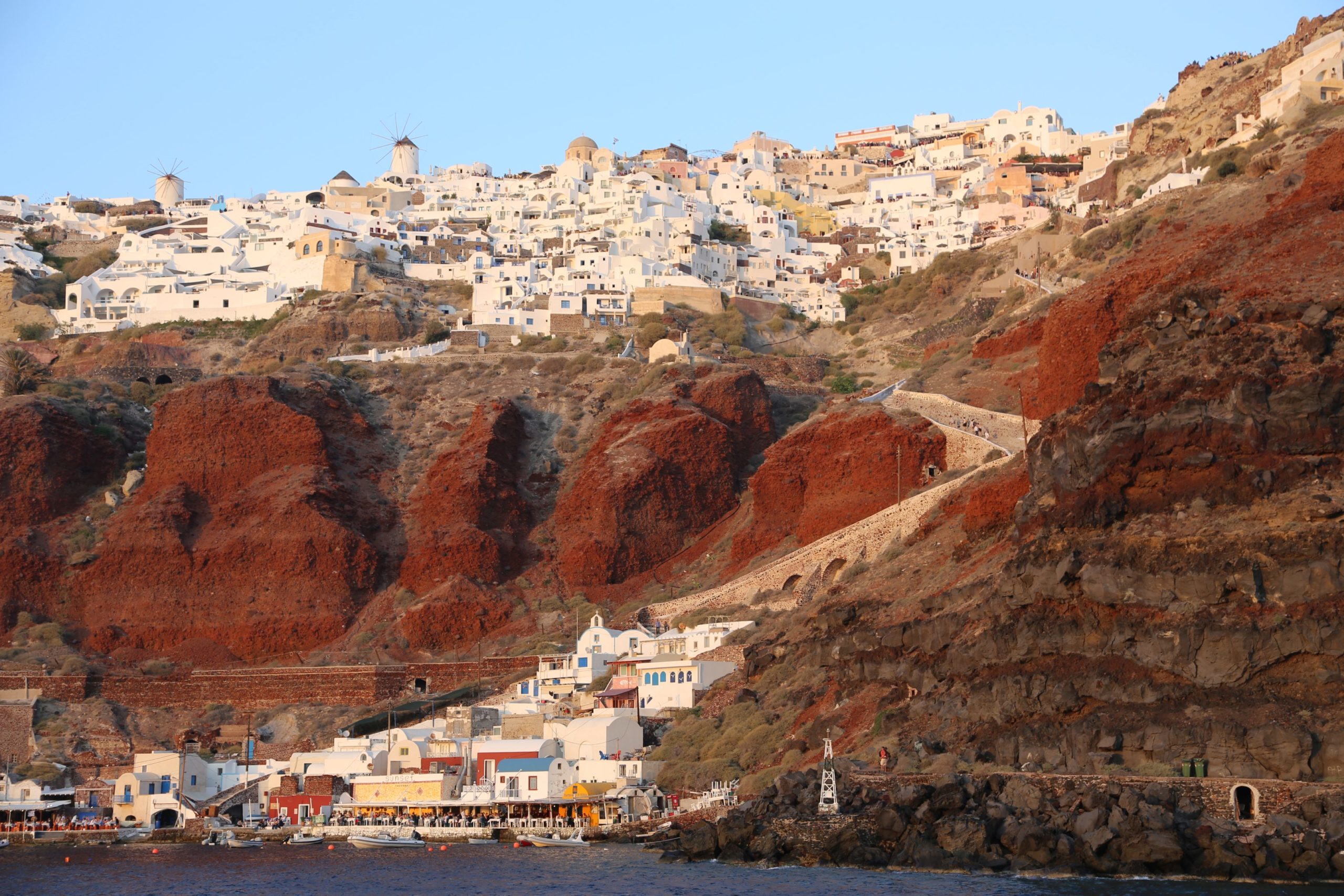 Imposanter Anblick von Oia vom Meer aus - Architektur, Caldera, Felsformationen, Gebäude, Klippen, Kraterrand, Oia, Steilküste, Windmühlen - (Oía, Ia, , Griechenland)