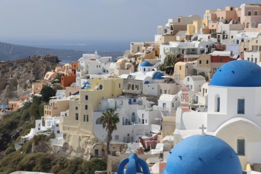 Dieses Anblick auf Oia wird niemals fad - Architektur, Blaue Kuppeln, Farben, farbenfroh, Festung, Gebäude, Meer, Oia, Palme - (Oía, Ia, , Griechenland)